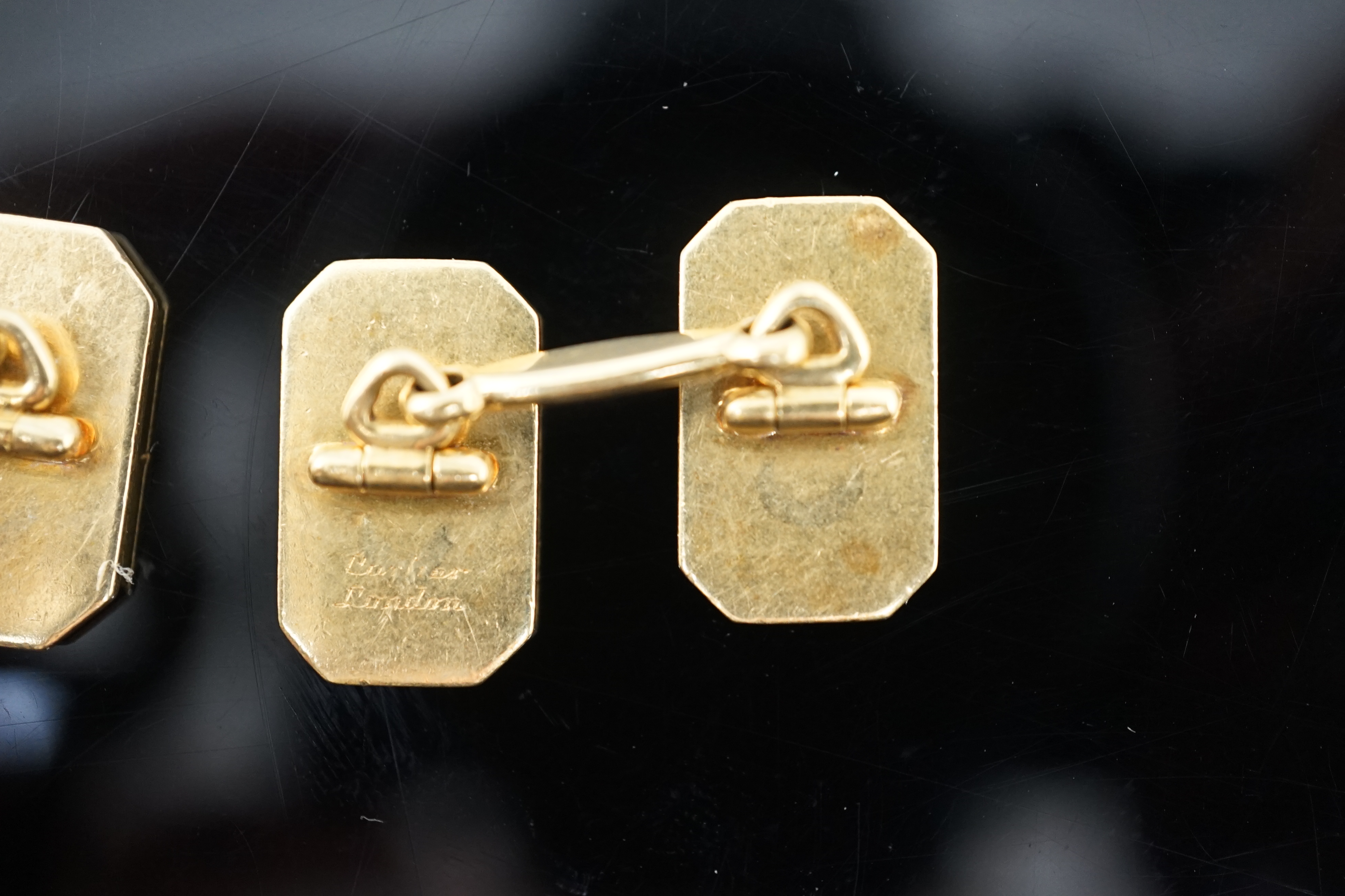 A pair of 1920's/1930's Cartier gold and two colour enamel rectangular Regimental cufflinks, with canted corners